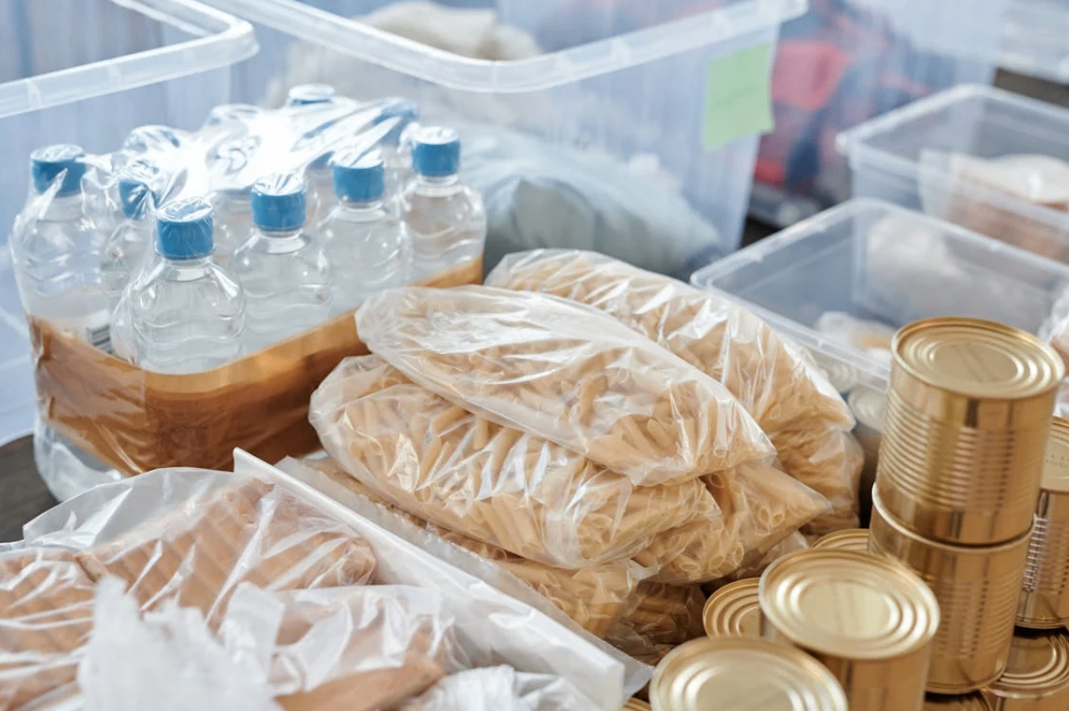 Packed food supplies including bottled water, canned goods, and pasta, prepared for distribution by Second Harvest Food Bank of Middle Tennessee.