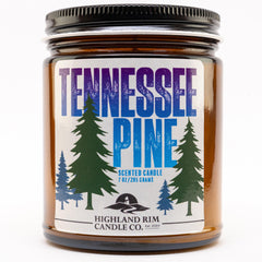 Studio shot of Tennessee Pine candle by Highland Rim Candle Co., featuring a green and blue label with pine tree illustrations, reflecting the scent of Tennessee’s forests.